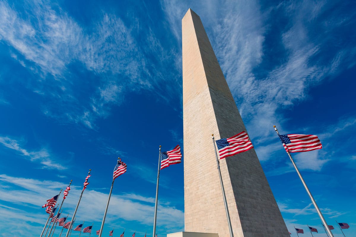 washington monument against blue sky with american flags