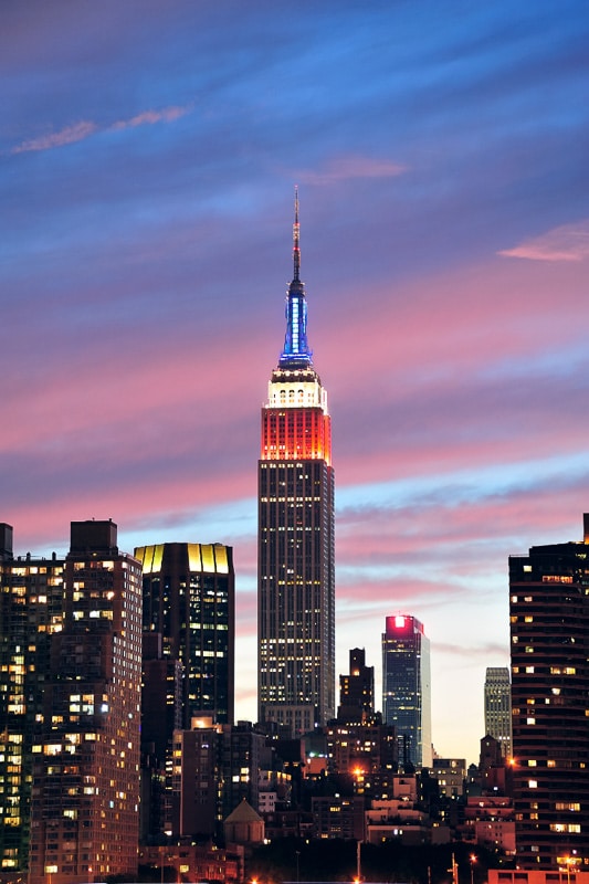 empire state building lit up against twilight sky